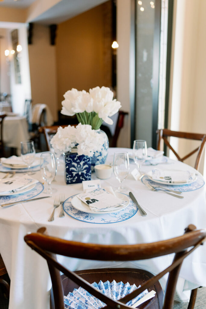 Elegant bridal shower setup at Matteo’s of Huntington – A beautifully decorated table with blue floral arrangements, elegant tableware, and soft lighting in the newly renovated Matteo’s of Huntington.