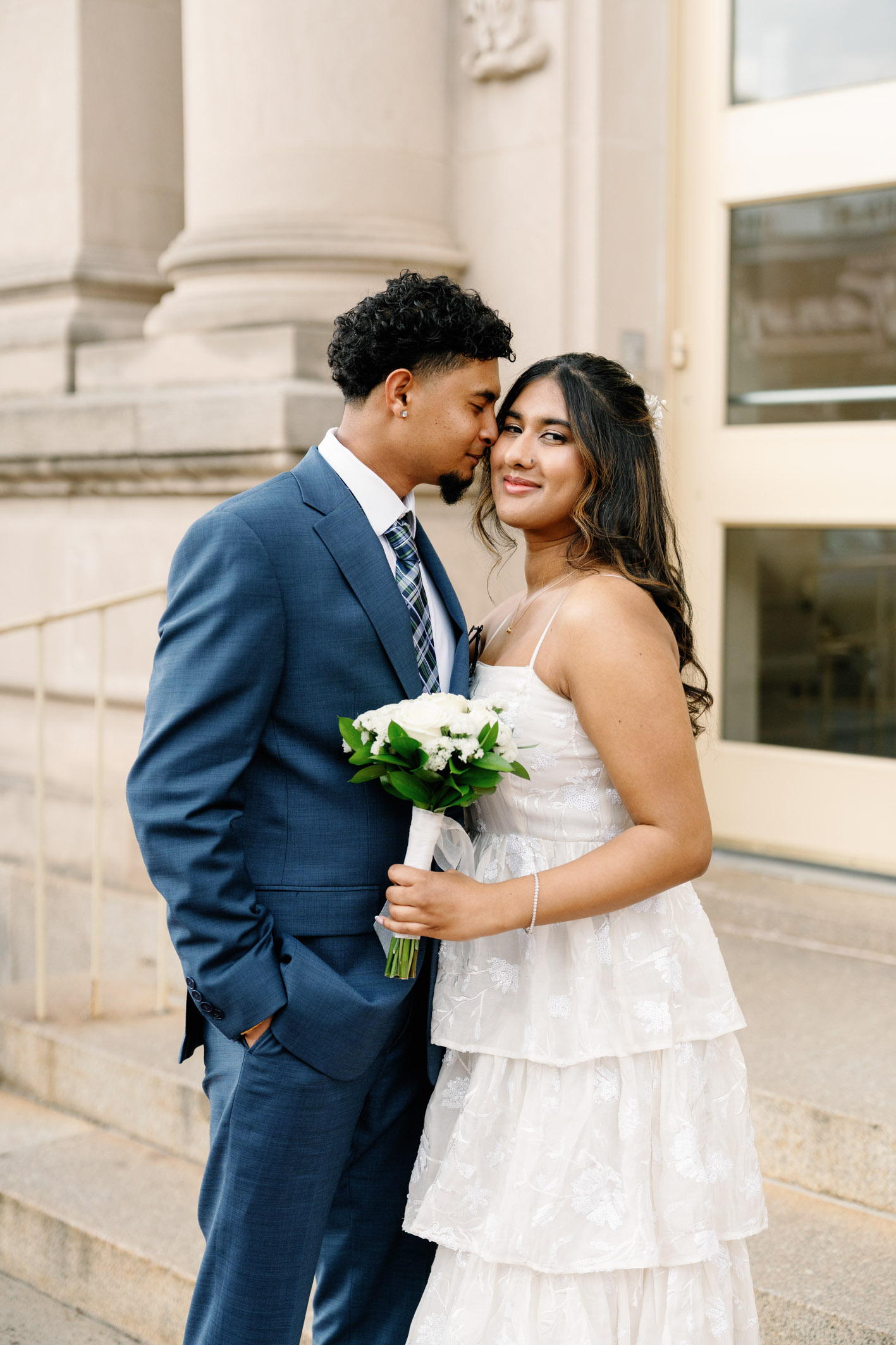 bride and groom in front of a court house in long island
