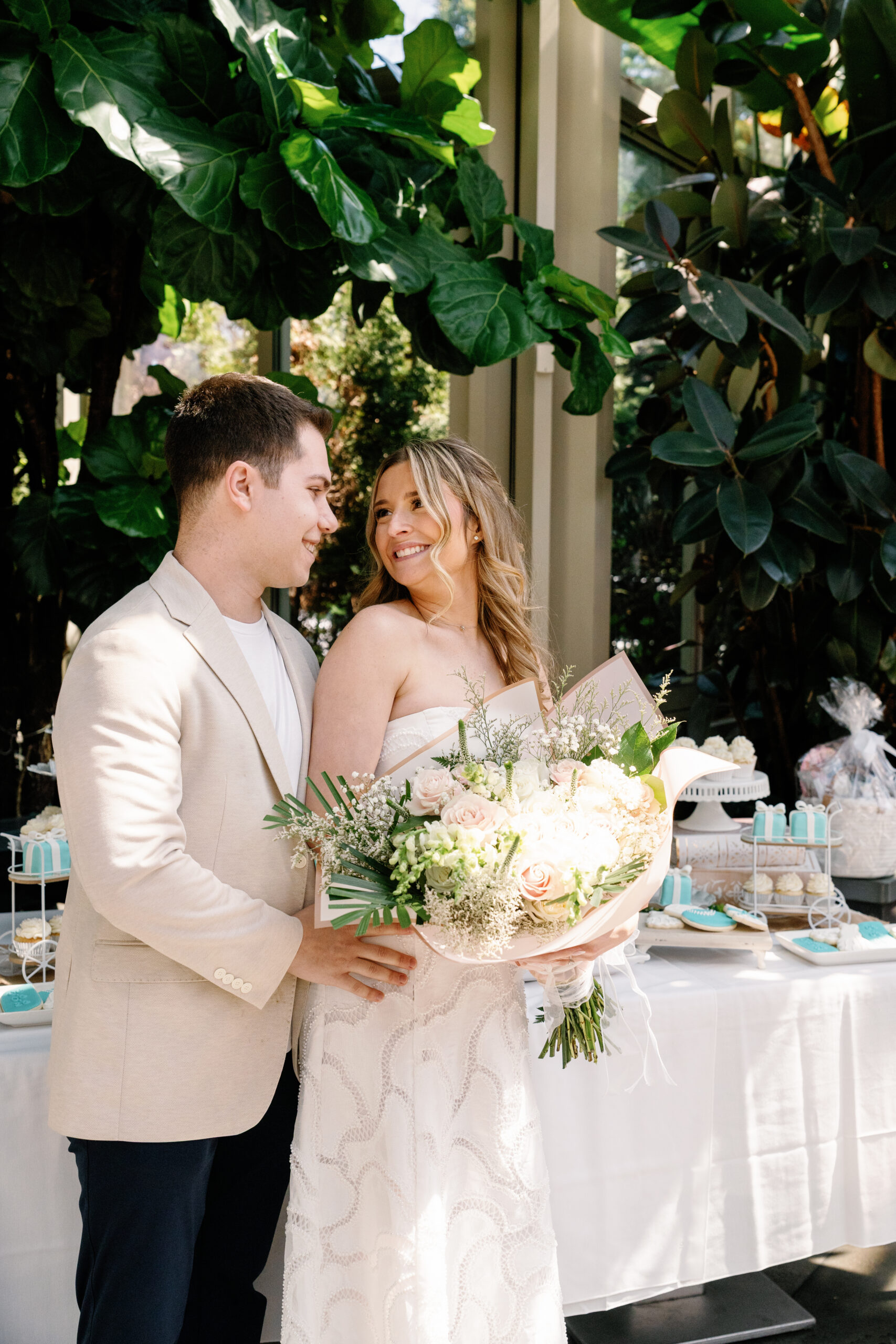a bride and groom-to-be in front of their dessert table