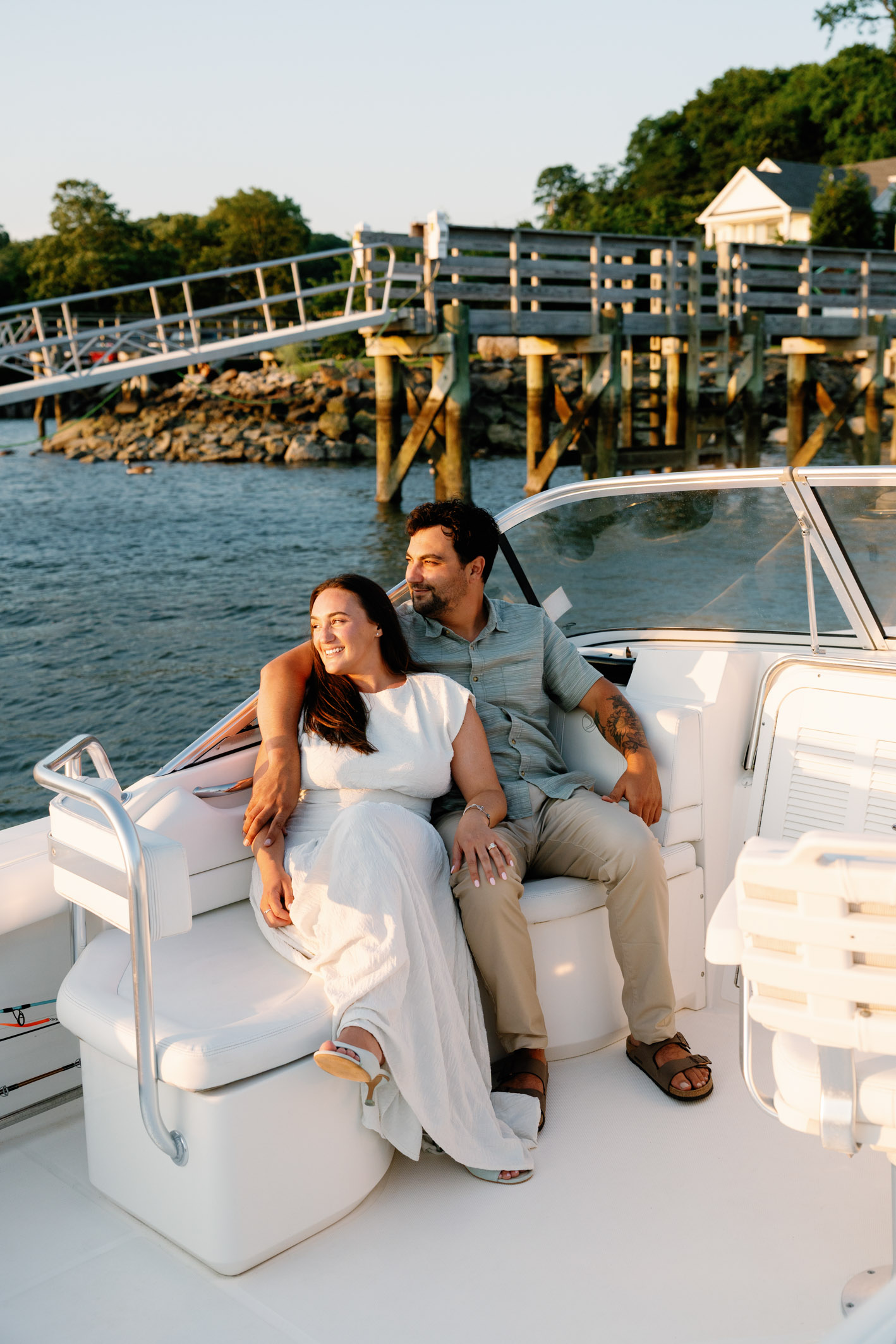 engaged couple sit on a boat together in Northport